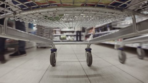 Shopping cart racing through the aisles of hypermarket sped up consumerism