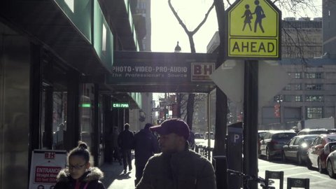 NEW YORK - NOV 29, 2015: young black male and girl walking outside BH Photo Superstore in Manhattan in the cold winter NYC. B&H Photo is a famous electronics store in NYC.