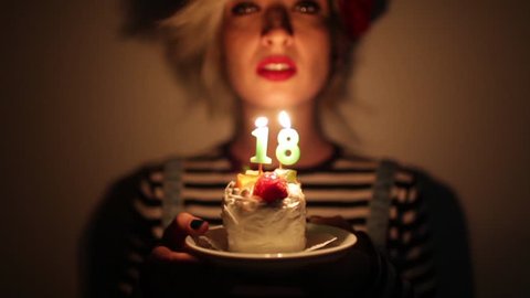 teenage girl celebrating her 18. birthday with a cake