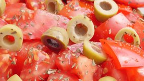 Juicy olives and tomatoes mixed in healthy salad with oil and spices close-up 4K 2160p 30fps UltraHD footage - Tasty green and red vegetable organic salad slow tilt 4K 3840X2160 UHD video