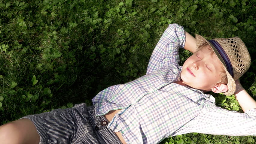 Little fella lying on the grass and relaxing under the warm sunrays