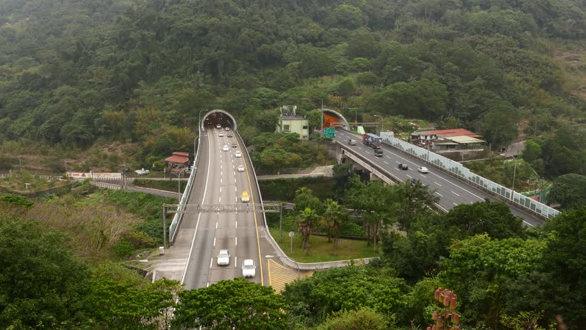 Ultramodern highway tunnels come out mountainside, general view, nature and forestry mountain slope. Formosa Fwy, Wenshan District, Taipei city, Taiwan.
