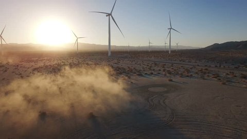 4K Aerial flying over wind turbines in desert at sunset