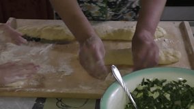 Grandmother with grandson knead the dough for pies