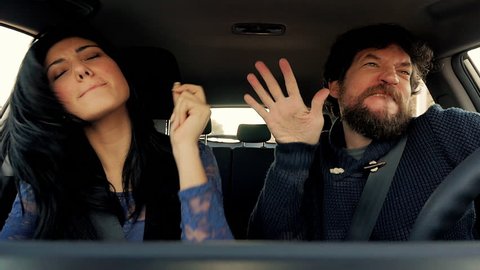 Funny man and woman dancing like crazy in car slow motion