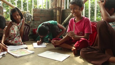 Simple, sweet Indian boys and girls smile, laugh and draw happily with each other in a rural school in Bengal