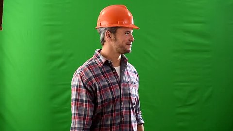 on a green background, a handsome builder with a hardhat, smiling at the camera, then he crosses his arms