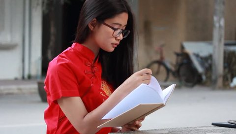 Portrait of thai teen beautiful girl in Chinese dress read a book.