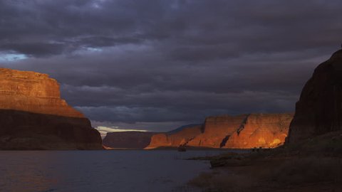 Wide time lapse shot of sunrise over rock formations / Lake Powell, Utah, United States