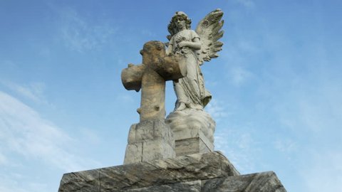 dolly around a cemetery angel on top of a tomb in New Orleans