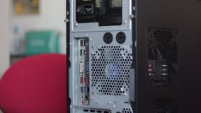 Hand connects too many cables to the back of the PC. Video is timelapse.