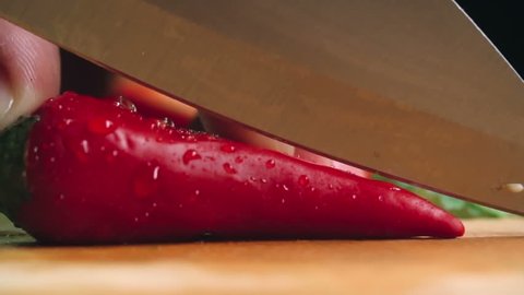 Close-up of cutting red hot pepper on cutting board