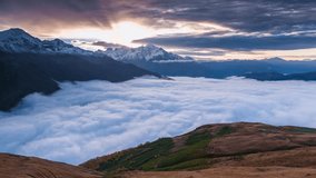 Time lapse clip. Flowing sea of fog at the foot of the Tetnuldi peak in autumn morning in the Caucasus mountains. Upper Svaneti, Georgia, Europe. 4K video (Ultra High Definition).