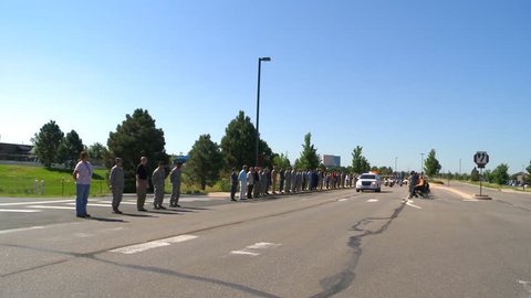 CIRCA 2010s - A military funeral process passes along a road.