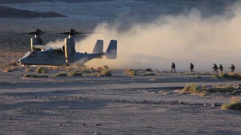 CIRCA 2010s - U.S. Marines board an Osprey helicopter in the desert and it takes off.