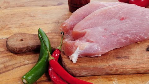 fresh raw turkey meat steak with hot sweet pepper dry spices castor and pepperbox on wood cutting boar over table 1920x1080 intro motion slow hidef hd