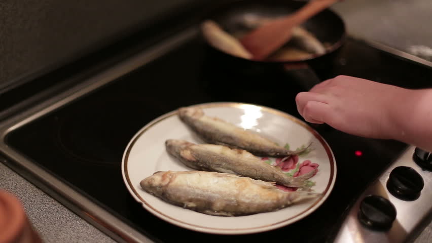 Frying fish in a frying pan.