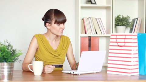 Attractive woman buying online with her laptop and credit card