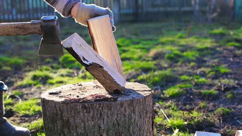 A man chops wood. Sunny