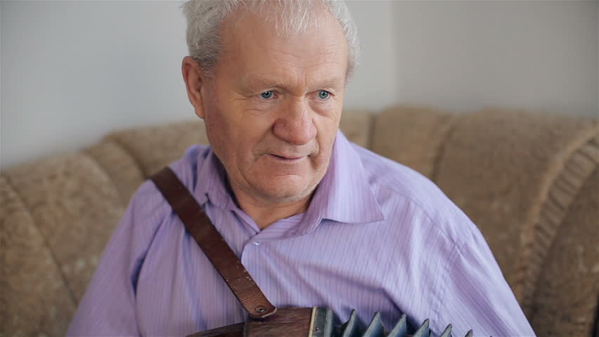 An old man playing the harmonica