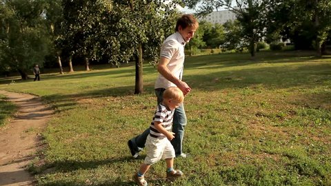 Father and son running on meadow 