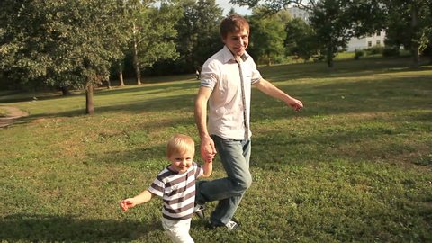 Father and son running on meadow 