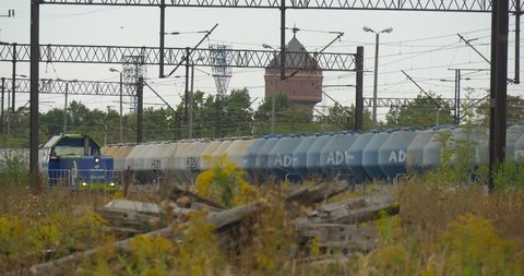 OPOLE/POLAND - SEP 18 2015: The railway station for freight trains in Opole Blue special rolling stock moves on the railway. Long cargo train stands on the railway track. Blue, grey tanks. Contact
