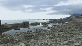 aerial video of rocky coastline with breakwaters for protection of sea shore