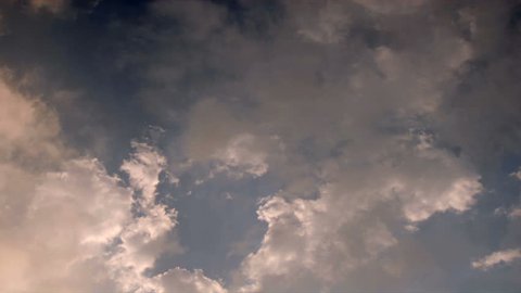 Time lapse misty clouds float across a gray blue sky.