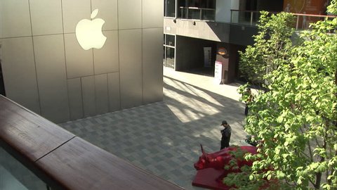Beijing, China - March 2009: A security guard walks with his walkie-talkie outside the Apple Store at the Taikoo Li shopping mall at Sanlitun, Beijing, China.