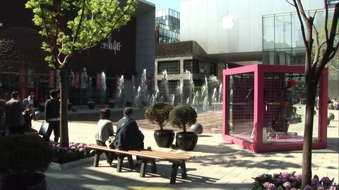 Beijing, China - March 2009: Chinese shoppers in the middle of the Taikoo Li shopping mall in Sanlitun area of Beijing, China. Water fountains in front of the Apple Store.