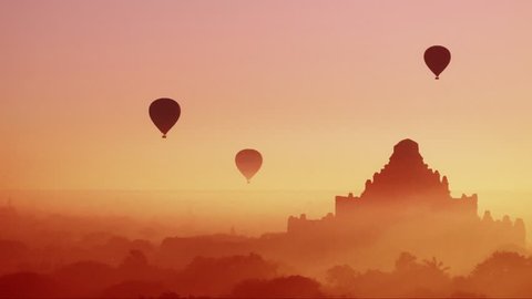 Hot air balloons flying at sunrise over ancient Buddhist Temples at Bagan. Myanmar (Burma) travel landscape and destinations