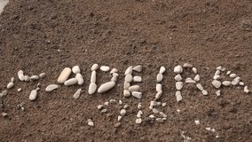 video footage of the word Madeira writting with stones at a beach. Madeira, Portugal