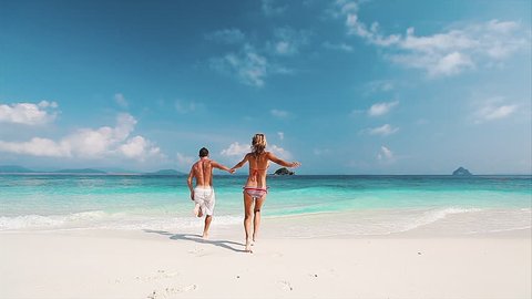 Couple running into the tropical sea