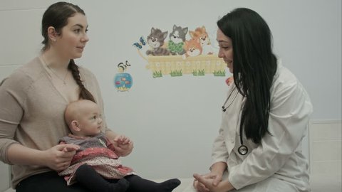 Cute baby being examine by pediatrician with toy