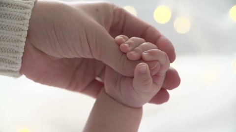 Mother and newborn daughter. Hand in hand.Slow motion.