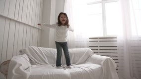 little Asian girl jumping on bed, slow motion