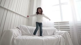 little Asian girl jumping on bed, slow motion