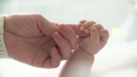 Mother and newborn daughter. Hand in hand.Slow motion.