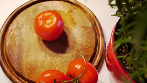 fresh tomato is cut quickly and professionally with a sharp knife on a wood board