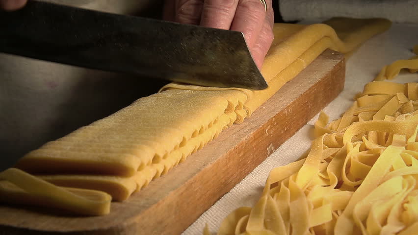 cutting Raw and long tagliatelle pasta: handmade spaghetti, fresh egg pasta