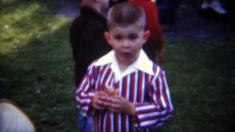 PITTSBURG 1953: 4th of July party boy dressed in patriotic stripes eating hotdog. - Βίντεο στοκ editorial