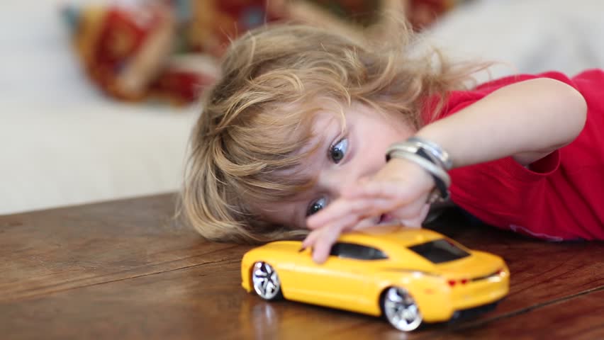 kid playing with toy car
