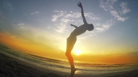 trace shows various jumps while running on beach sunset sand, backflip, cartwheel, SLOW MOTION