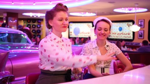 MOSCOW - JAN 18, 2015: Two girls dance in bar (models with releases) at Retro Beauty Day in Beverly Hills Diner