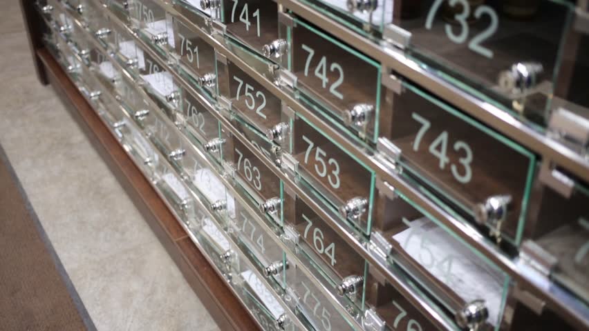 Many transparent mailboxes with numbers in large residential building