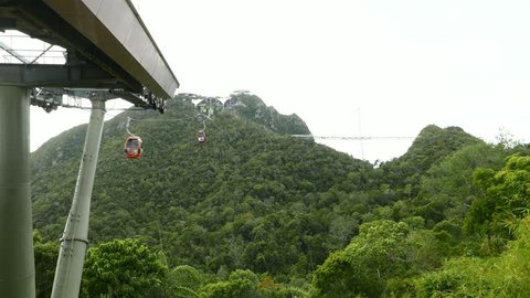 LANGKAWI, MALAYSIA - MARCH 02, 2015: Gondola lift system against green mountain ridge, time lapse, Langkawi Skybridge observation desk above rainforest nature at highlands, Gunung Mat Chinchang peak