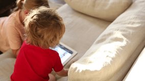Young siblings watching a movie together on a tablet