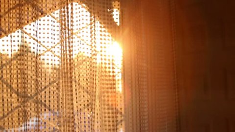 Sun shine through a curtain during sunset.