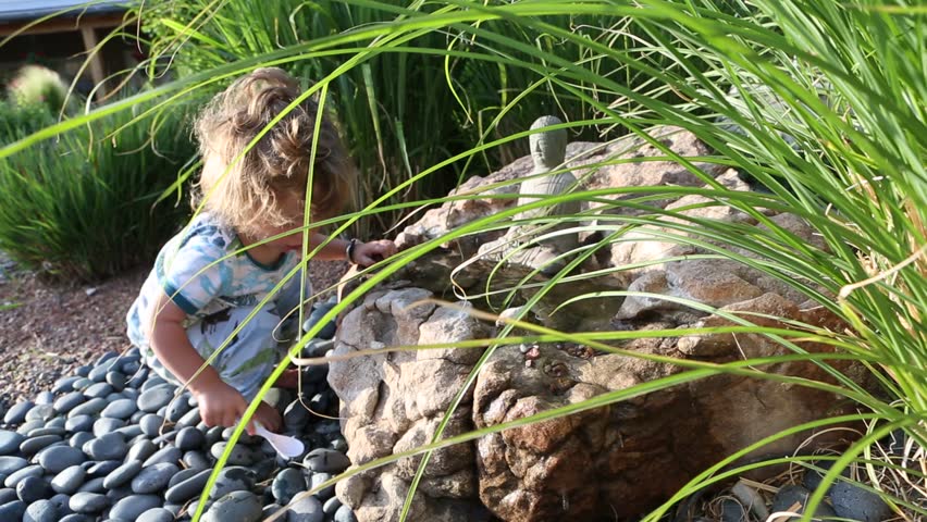 Toddler boy playing by fountain